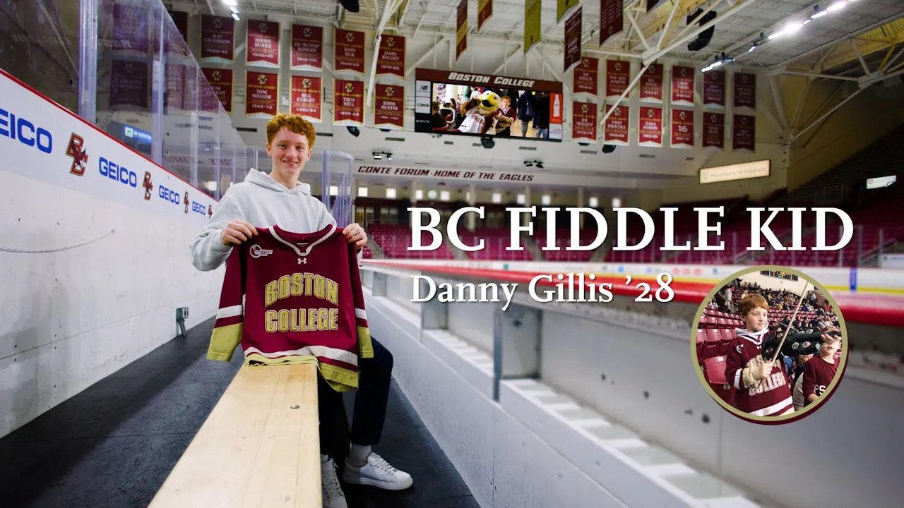 Dan Gillis holding a 51 hockey jersey in sitting in Kelley Rink