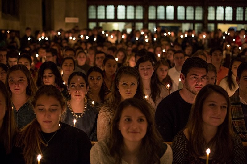 A group of students holding candles during mass