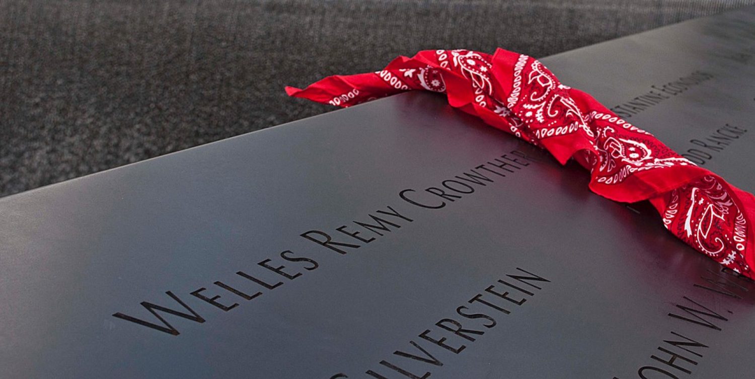A red bandana draped over a granite marker